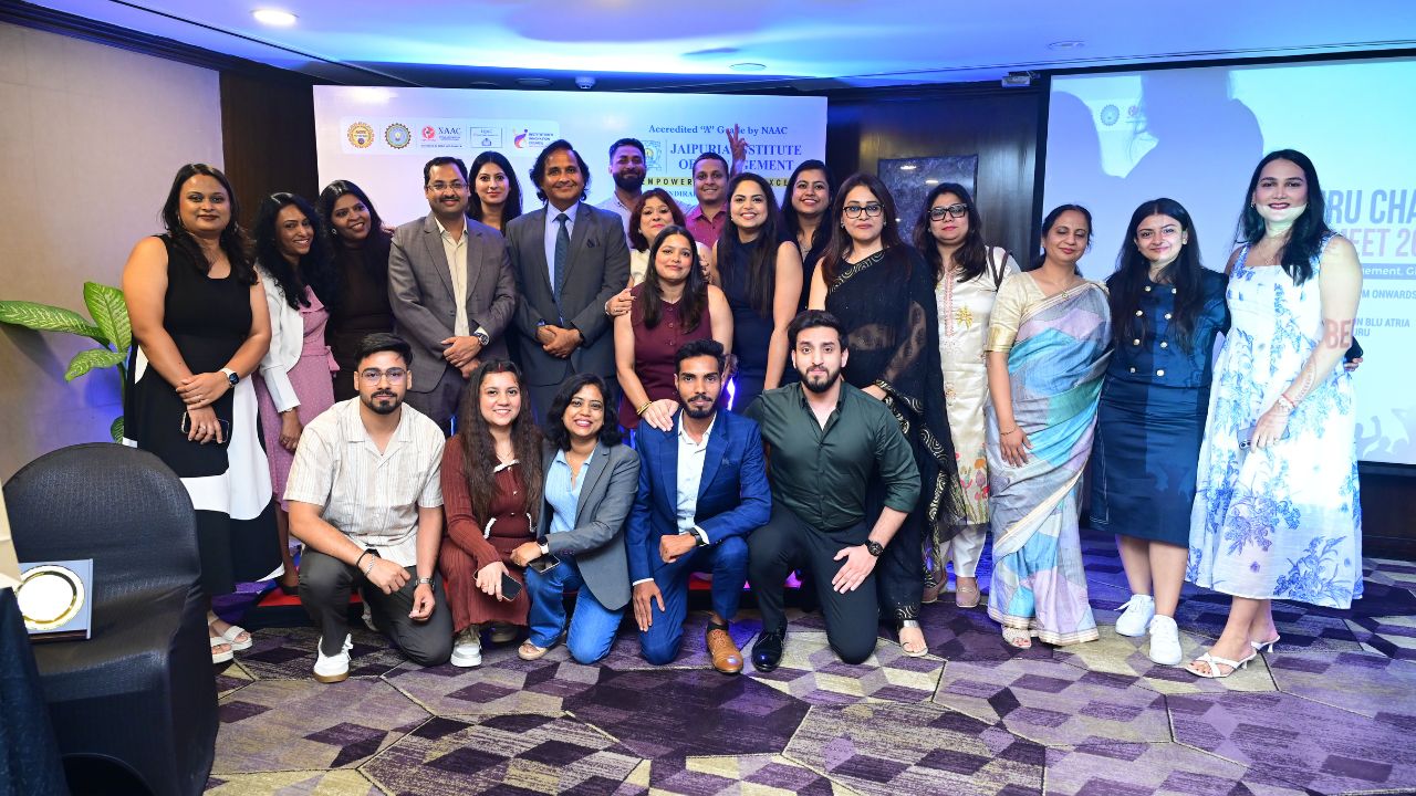 Alumni and institutional leadership pose together on stage at the Bengaluru Chapter Alumni Meet 2026